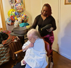woman blowdrying the hair of the elderly